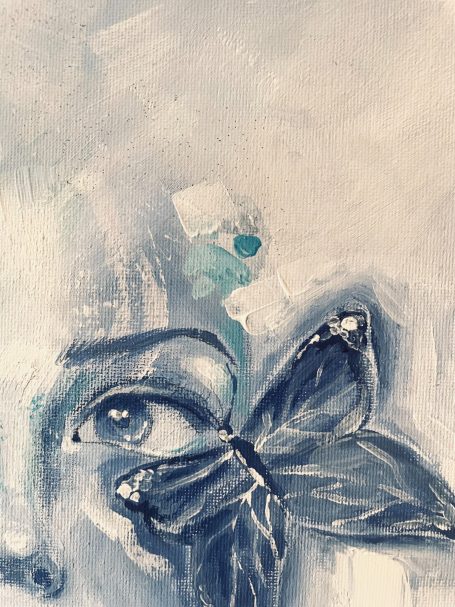 Ein Gesicht mit einer blauen Schmetterlingsillustration neben dem Auge.